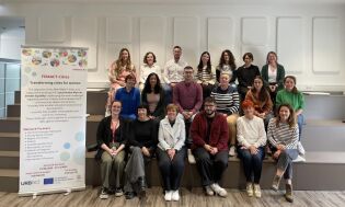 Zdjęcie grupowe członków sieci planowania działań FEMACT-Cities obok banera projektu dotyczącego przekształcania miast z myślą o kobietach.