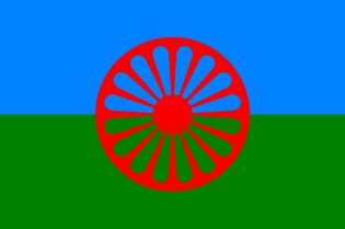 Flaga Romska. Dwa pasy niebieski symbolizujący duchowość i niebo i zielony symbolizujący ziemię a pośrodku motyw czerwonego koła indyjskiej czakry.  