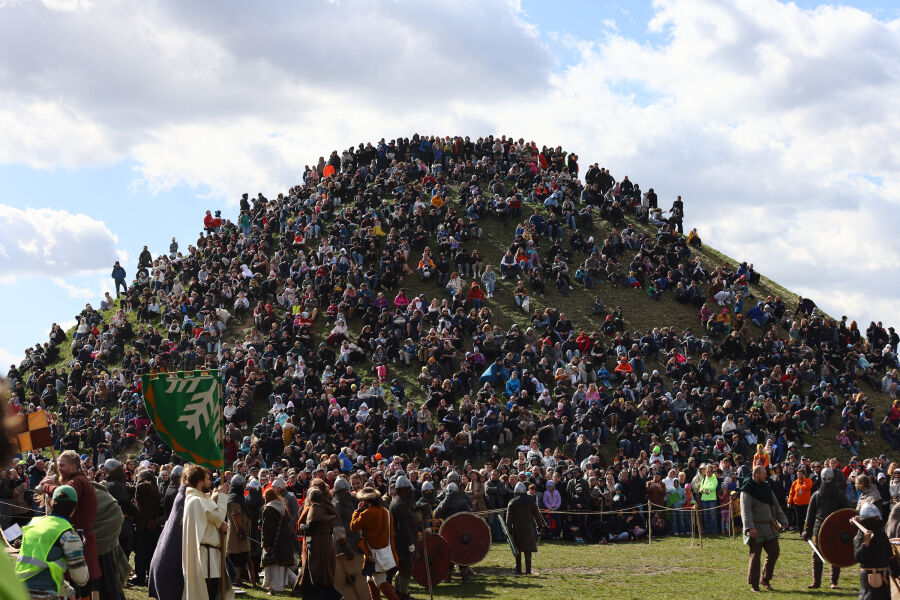 Tłum ludzi zgromadzony u stóp i na Kopcu Krakusa podczas wydarzenia plenerowego. Słoneczny dzień, jasne niebo. Uczestnicy obserwują wydarzenia i spacerują po terenie, tworząc żywą, otwartą przestrzeń.