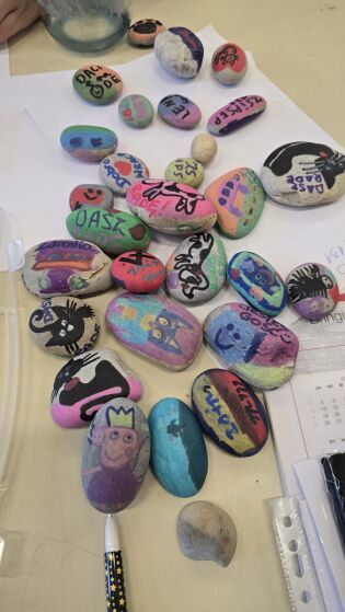 Obraz przedstawia pomalowane kamyki rożnymi wzorami. 