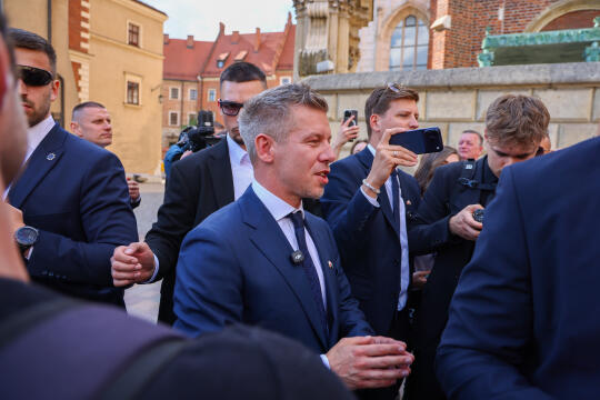 Premier Węgier Péter Magyar podczas wizyty w Krakowie. Na zdjęciu widoczny jest spacer ulicą miasta w asyście ochrony, w tle zabudowa miejska w pogodny dzień.