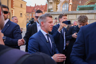 Premier Węgier Péter Magyar podczas wizyty w Krakowie. Na zdjęciu widoczny jest spacer ulicą miasta w asyście ochrony, w tle zabudowa miejska w pogodny dzień.