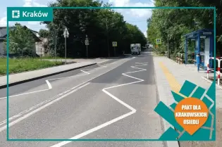 Droga z pasami ruchu, znaki drogowe i przystanek autobusowy w otoczeniu zieleni.