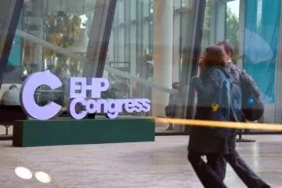 EHP Congress z dużymi literami na tle nowoczesnego budynku. Ludzie przechodzą obok.