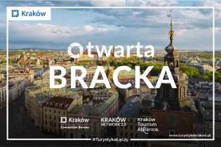 Widok na krakowski rynek z wieżą kościoła i zabytkowymi budynkami.