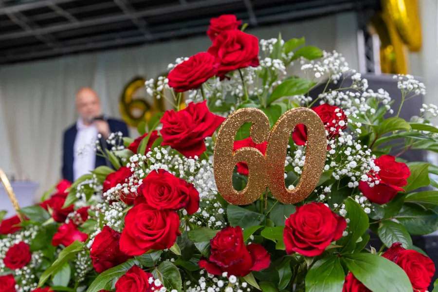 Bukiet czerwonych róż z cyfrą 60 w złotym kolorze.