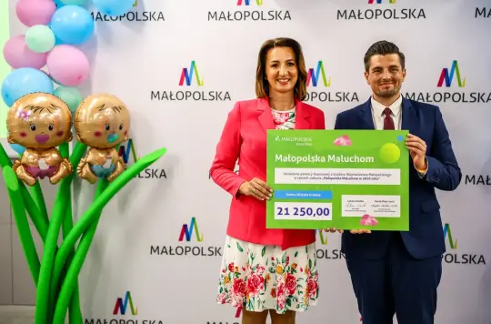 Pani Marta Malec-Lech z Zarządu Województwa Małopoolskiego wręcza bon "Małopolska Maluchom" na kwotę 21 250,00 zł  Dyrektorowi Wydziału Polityki Społecznej, Równości i Zdrowia Panu Sebastianowi Lipows