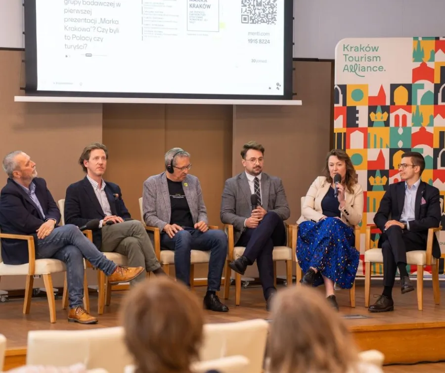 Panel dyskusyjny z pięcioma mężczyznami i jedną kobietą na temat turystyki w Krakowie.