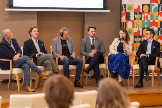 Panel dyskusyjny z pięcioma mężczyznami i jedną kobietą na temat turystyki w Krakowie.