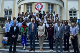 Grupa ludzi stojąca przed eleganckim budynkiem.