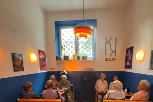Grupa starszych kobiet siedzących w kawiarni, rozmawiających i spędzających czas razem.