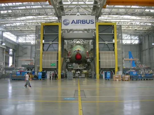 Hala produkcyjna Airbusa z samolotem w trakcie montażu.
