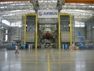 Hala produkcyjna Airbusa z samolotem w trakcie montażu.