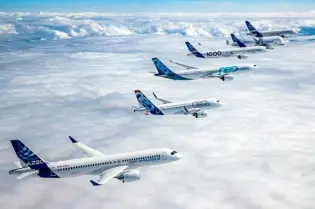 Grupa samolotów Airbus w locie nad chmurami.