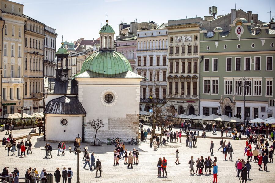 Panorama Rynku Głównego z drona. Widoczne jest kościół św. Wojciecha. Na płycie Rynku widać małe sylwetki przebywających tam osób.   