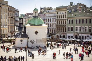Panorama Rynku Głównego z drona. Widoczne jest kościół św. Wojciecha. Na płycie Rynku widać małe sylwetki przebywających tam osób.   
