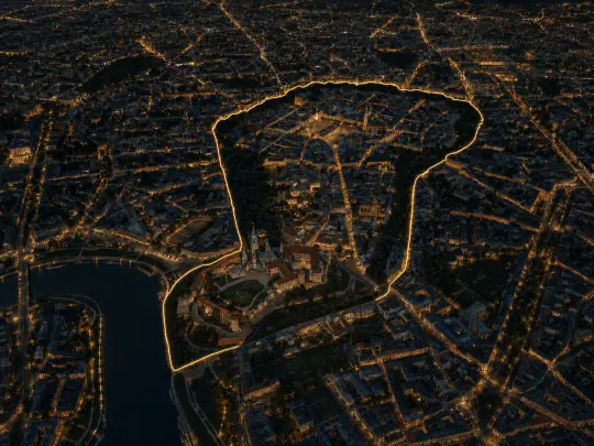 Widok na miasto nocą z podświetloną granicą historycznego obszaru.