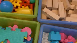 Kolorowe klocki i zabawki w plastikowych pojemnikach.
