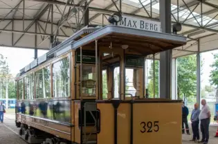 Zabytkowy tramwaj w hali wystawowej, z numerem 325 i nazwiskiem Max Berg.