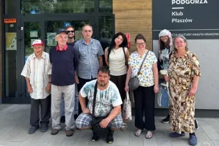 Grupa osób pozująca przed wejściem do Klubu Płaszów.