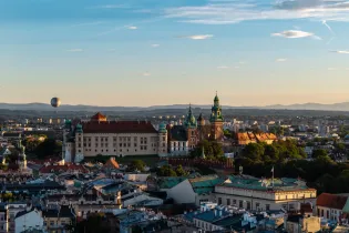 Wawel z zamkiem, balon na niebie, panorama Krakowa w tle.