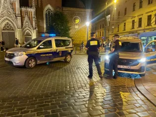 Interwencja straży miejskiej w miejskim otoczeniu nocą.