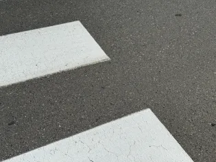 Pasy ruchu na szarej nawierzchni asfaltowej.