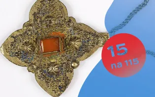 Złoty wisiorek w kształcie kwadratu z czerwonym kamieniem w środku.