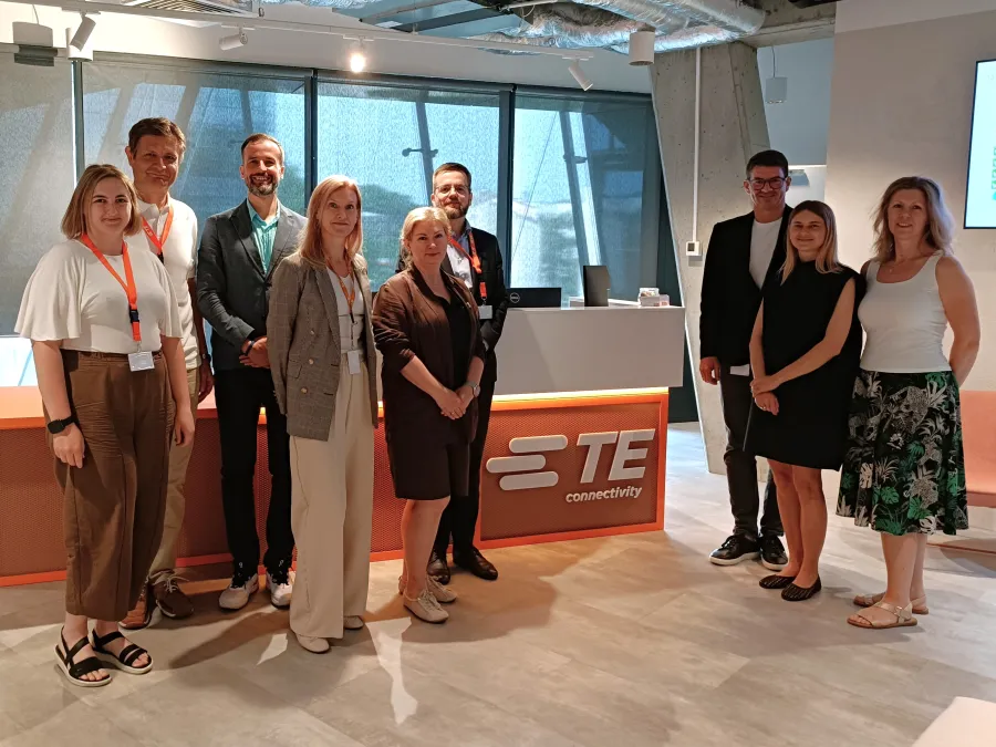 Grupa osób stojąca w biurze TE Connectivity.