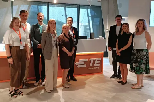 Grupa osób stojąca w biurze TE Connectivity.