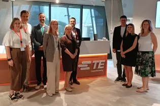 Grupa osób stojąca w biurze TE Connectivity.