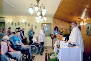 Msza święta w kaplicy z uczestnikami, w tym osobami starszymi i niepełnosprawnymi.
