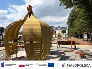Nowoczesna konstrukcja architektoniczna w kształcie owocu w przestrzeni publicznej.