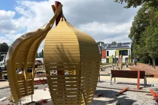 Nowoczesna konstrukcja architektoniczna w kształcie owocu w przestrzeni publicznej.