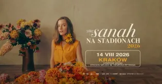 Kobieta w żółtej sukience w otoczeniu kolorowych kwiatów, zaprasza na koncert w Krakowie.