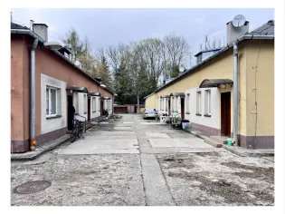 Osiedle domków jednorodzinnych z rowerem i samochodem na podjeździe.
