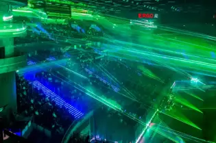 Kolorowe lasery oświetlają halę sportową w Sopocie, wypełnioną widzami.