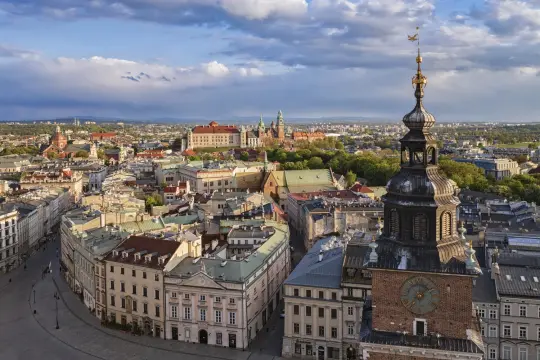 Widok na Kraków z wieży, z Wawel i chmurami na tle nieba.
