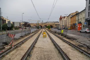 Torowisko tramwajowe z widokiem na architekturę miejską i remontowane ulice.