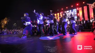 Grupa tancerzy wykonująca choreografię na scenie podczas występu.