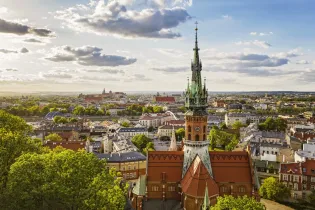 Widok na Kraków z wieżą kościoła i panoramą miasta w tle.