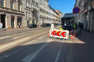 Roboty drogowe na ulicy, z barierkami i znakami drogowymi.