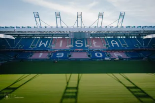 Stadion Wisły Kraków z widoczną datą 1906 na trybunach.