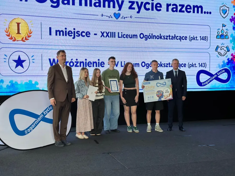 Uczniowie odbierają nagrody za osiągnięcia w konkursie edukacyjnym.