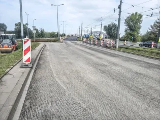 Droga z oznaczeniami robót budowlanych i sygnalizacją, widok na skrzyżowanie.
