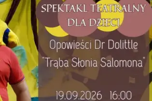 Mężczyzna w kostiumie żółtego słonia na tle kolorowej scenografii teatralnej.