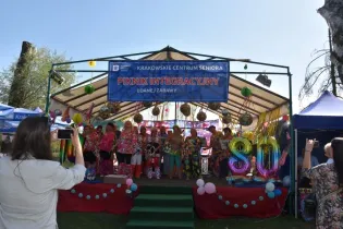 Piknik integracyjny z seniorami, kolorowe stroje, dekoracje i balony.