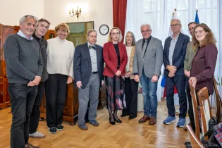 W gabinecie Prezydenta Miasta Krakowa grupa uśmiechniętych osób stoi w rzędzie pozując do zdjęcia. W środku pełniący funkcję Prezydenta Miasta Krakowa Stanisław Kracik.  