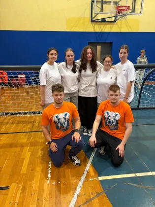 Grupa osób w strojach sportowych na boisku, przygotowujących się do gry.