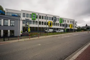 Nowoczesny budynek z kolorowymi balkonami i otoczeniem ulicy.